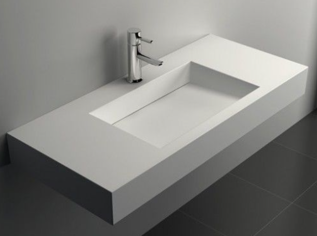 Lavabo moderno de Corian con diseño minimalista, grifo de acero en superficie blanca.